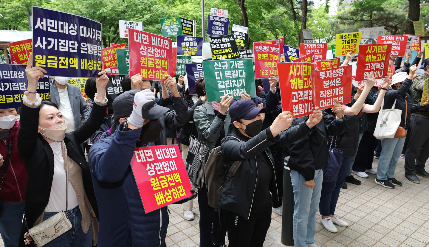 Members of a victims’ group related to the Hang Seng Index-linked equity-linked securities (ELS) fallout chant slogans at a news conference in front of the Financial Supervisory Service in Yeouido, western Seoul, on April 24, 2024, calling for the prosecution of financial institutions, executives and a former financial regulator chief, and demanding full compensation. [YONHAP]