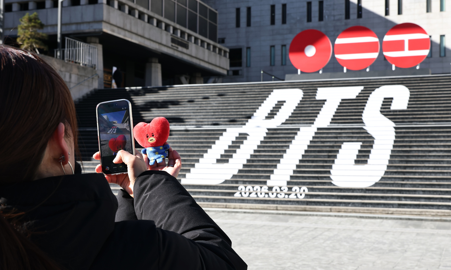 A tourist takes a photo of a promotional event announcing boy band BTS's comeback, at the Sejong Center for the Performing Arts in Jongno District, central Seoul, on Jan. 22. [YONHAP]