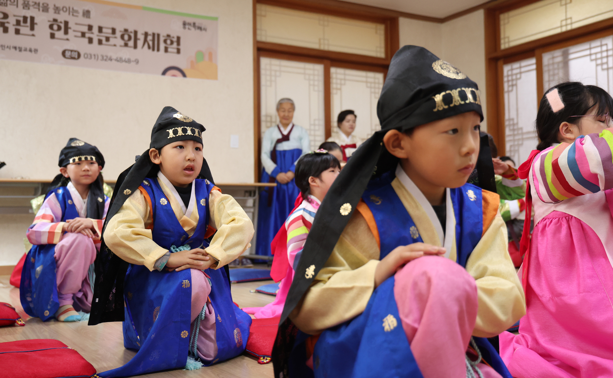 Participants from multicultural families learn how to perform a traditional New Year’s bow during a special Seollal holiday class and experience program at the Yongin Etiquette Education Center in Yongin, Gyeonggi, on Jan. 22. [NEWS1]  