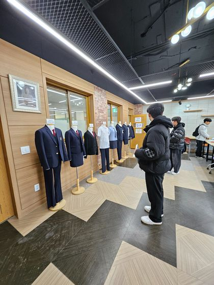 Incoming male students take a look at their new school uniforms at a high school run by Dongguk University. The school is set to transition from girls-only to co-ed starting in the upcoming spring semester. [GARAM HIGH SCHOOL]