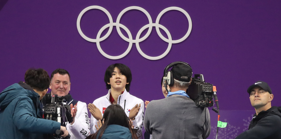 Cha Jun-hwan, center, checks his score after finishing his short program at Gangneung Ice Arena at the 2018 Winter Olympics in Gangwon on Feb. 16, 2018. [YONHAP]