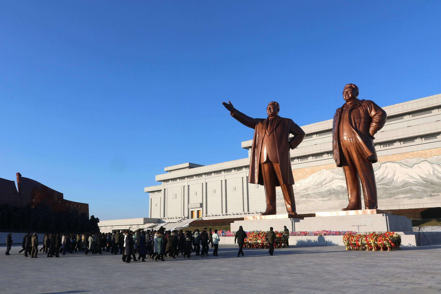 Members of the public and soldiers pay respect to former North Korea leaders Kim Il Sung and Kim Jong-il in front of their statues on Mansu Hill on New Year's Day in Pyongyang, North Korea, on Jan. 1.  [AP/YONHAP]