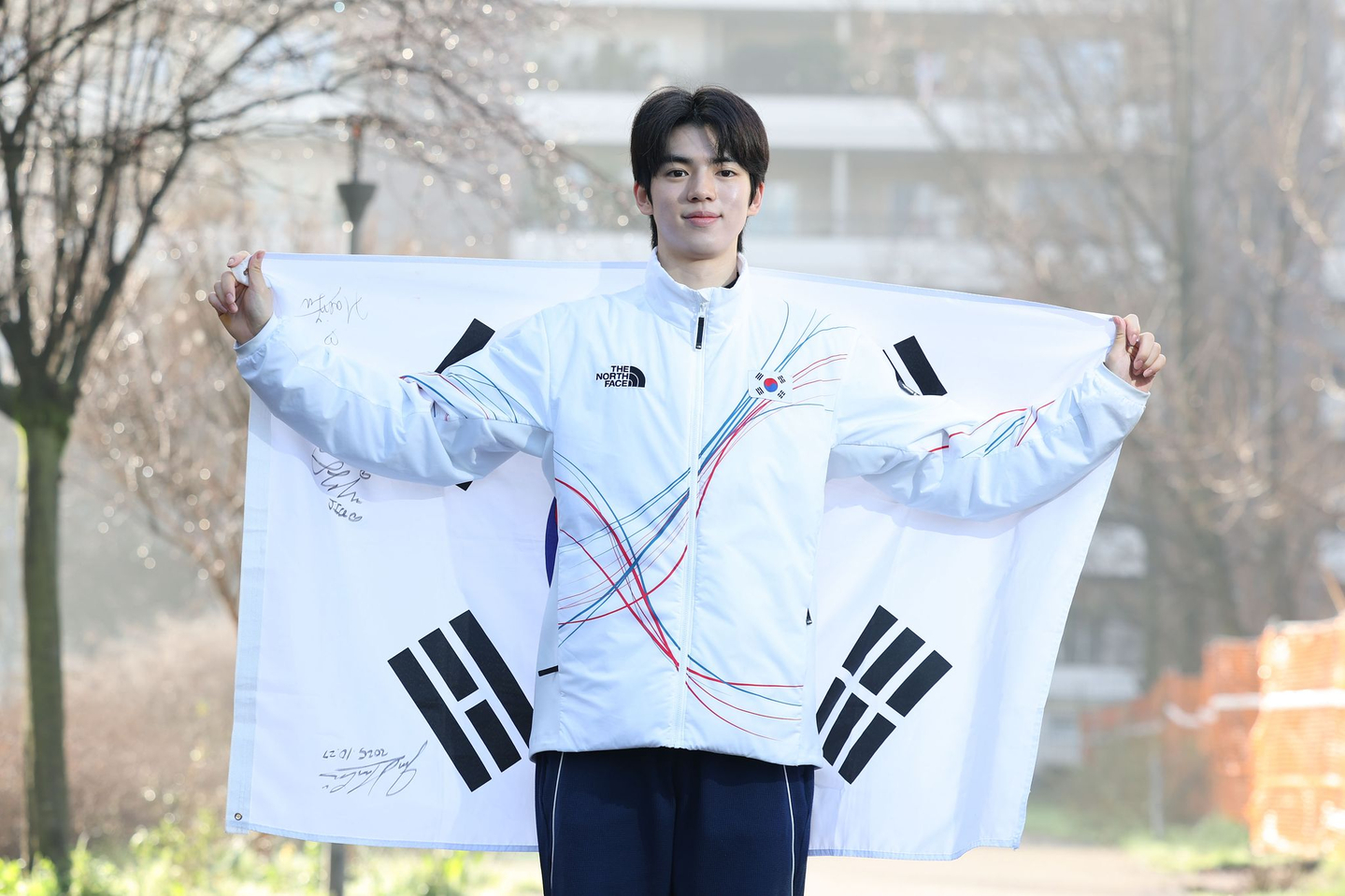 Korean figure skater Cha Jun-hwan holds up the national flag during an interview with the JoongAng Ilbo at the Olympic Village in Milan on Feb. 15. [KIM JONG-HO]