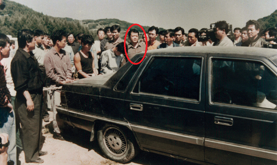Chijon Family gang members reenact a crime scene with a Hyundai-made Grandeur in an undated photo. Detective Koh Byung-cheon, circled, is also seen in the photo. [KOH BYUNG-CHEON]