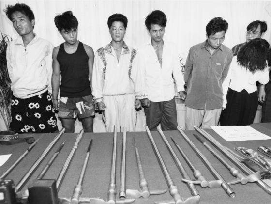The Chijon Family gang members are photographed in front of their weapons in September 1994. [JOONGANG ILBO] 