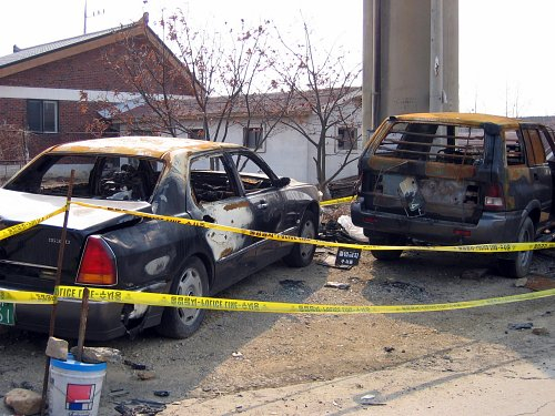 Burned SUV and sedan vehicles, owned by Kang Ho-sun, are seen abandoned in Ansan, Gyeonggi, in February 2009. [YONHAP]  