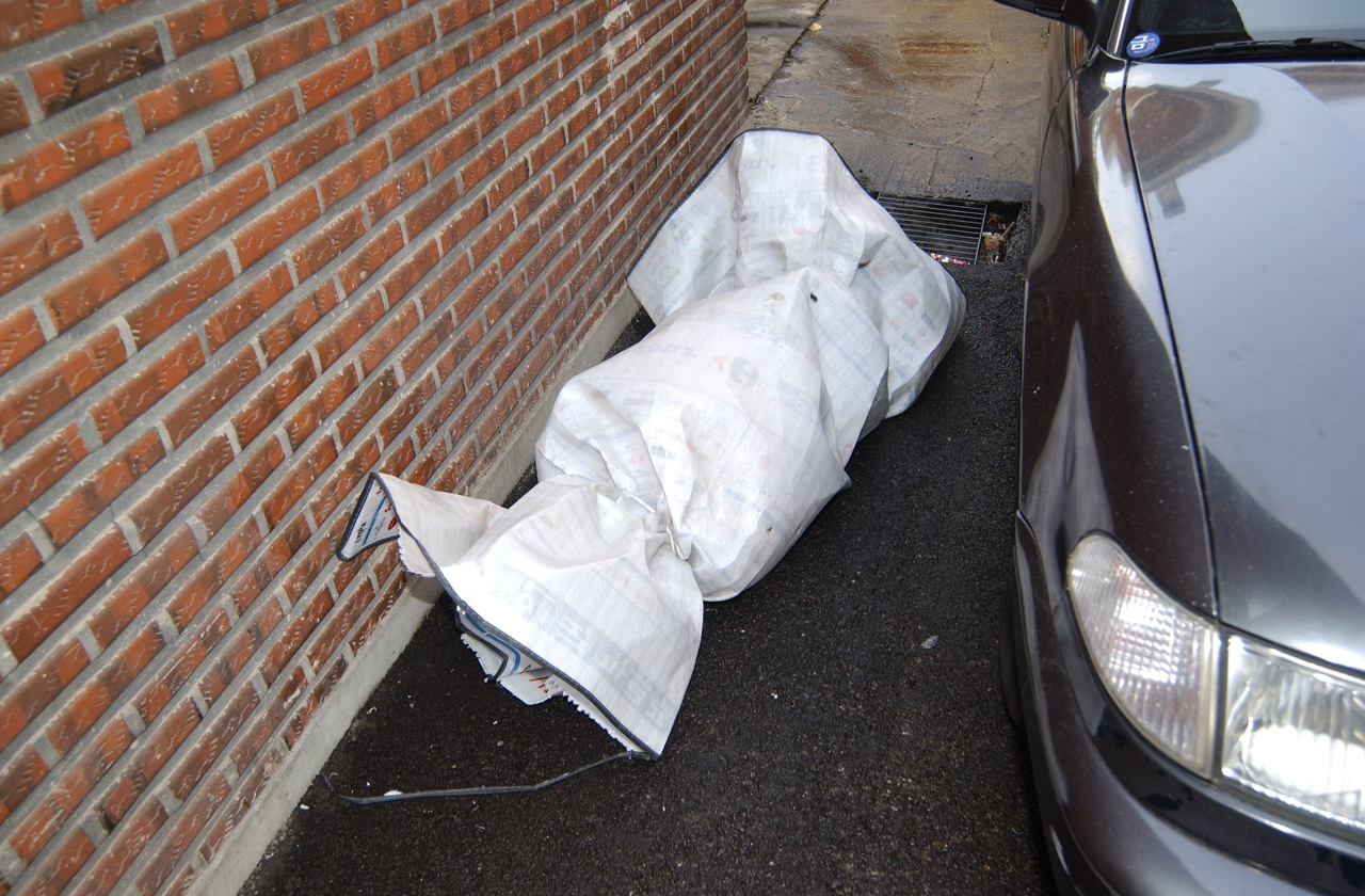 A body wrapped in a picnic mat and tied with strings was found in a parking lot in a residential area in Sinjeong-dong, western Seoul, in November 2005. [SEOUL METROPOLITAN POLICE AGENCY]