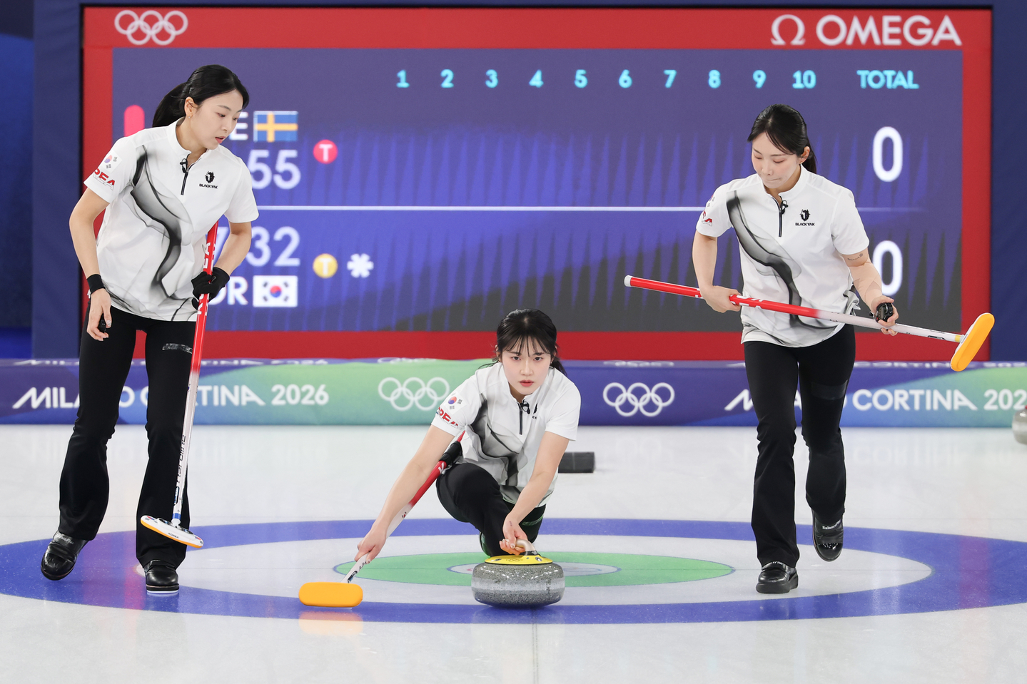 Seol Ye-eun of Korea, center, delivers a stone between teammates Kim Min-ji, left, and Kim Su-ji during the team's round-robin match against Sweden in the women's curling tournament at the Winter Olympics at Cortina Curling Olympic Stadium in Cortina d'Ampezzo, Italy, on Feb. 18, 2026.  [YONHAP] 