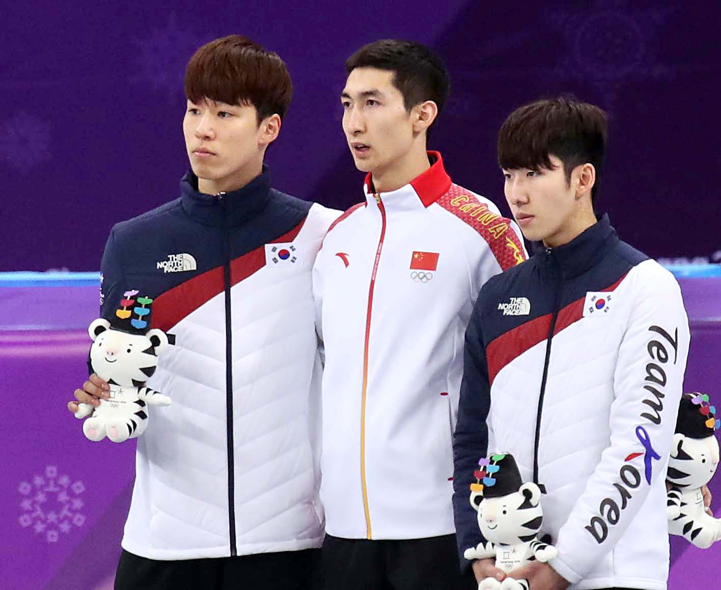 Silver medalist Hwang Dae-heon, left, and bronze medalist Lim Hyo-jun, right, pose for a photo with gold medalist Wu Dajing of China at Gangneung Arena on Feb. 22, 2018. [OH JONG-TAEK]
