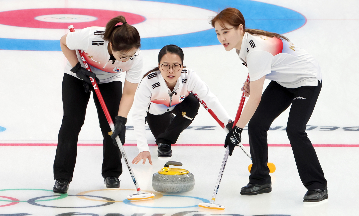 Kim Eun-jung, center, delivers a stone during the round-robin match against the United States at the Beijing 2022 Winter Olympics. The game was held at the National Aquatics Centre in Beijing, China, on Feb. 14, 2022. [JOONGANG ILBO]