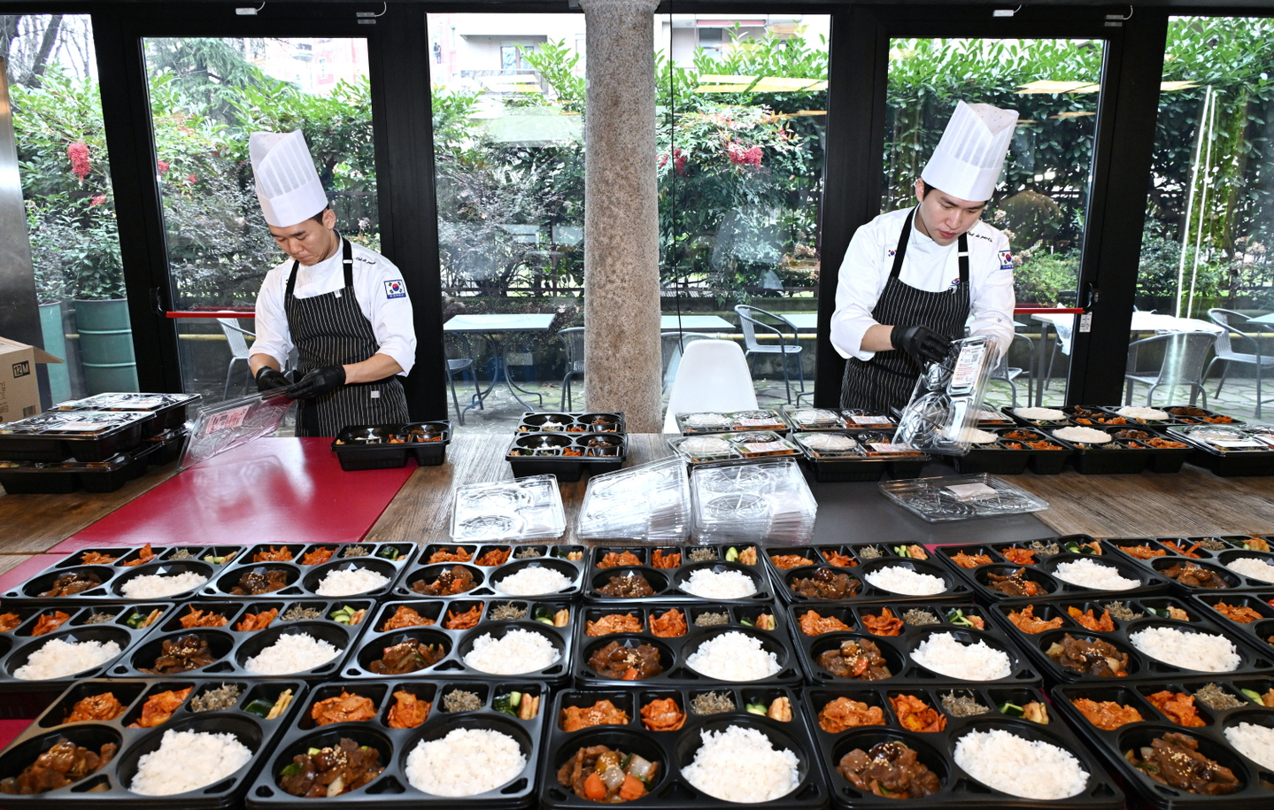 Chefs prepare meal boxes for athletes at the Korean Sport & Olympic Committee’s meal support center in Milan. [KOREAN SPORT & OLYMPIC COMMITTEE]