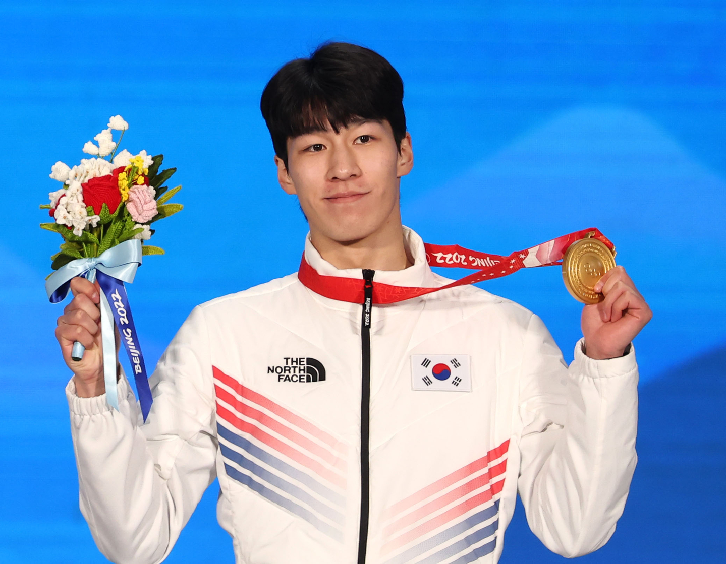 Short track speed skater Hwang Dae-heon holds his gold at a medal ceremony held on Feb. 10, 2022, after winning the 1,500-meter event at the Beijing Winter Olympics. [YONHAP]