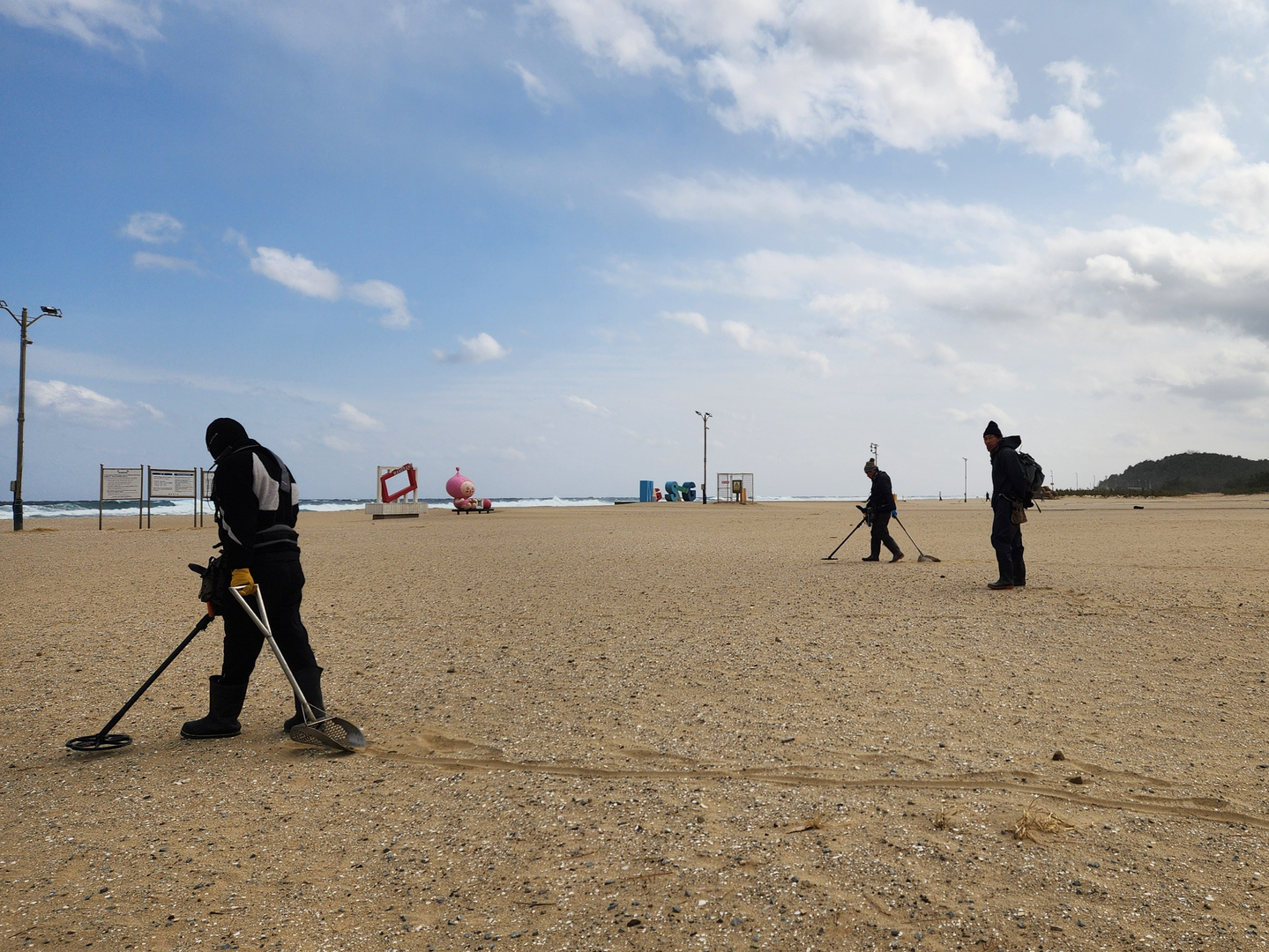 Members of a metal detecting club are seen searching for gold at Mangsang Beach in Donghae, Gangwon, on Feb. 6. [LEE GYU-RIM]