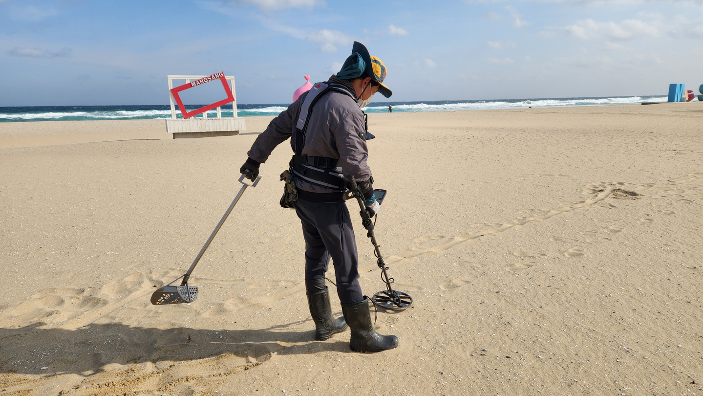 A member of a metal detecting club searches for gold at Mangsang Beach in Donghae, Gangwon, on Feb. 6. [LEE GYU-RIM]