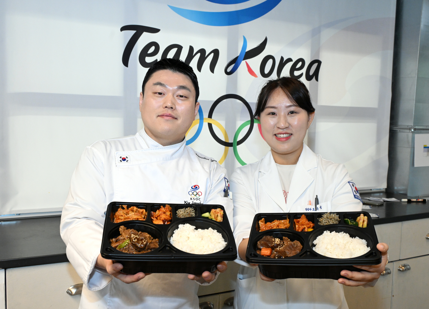Chefs hold up meal boxes prepared at the Korean Sport & Olympic Committee’s meal support center in Milan. [KOREAN SPORT & OLYMPIC COMMITTEE]