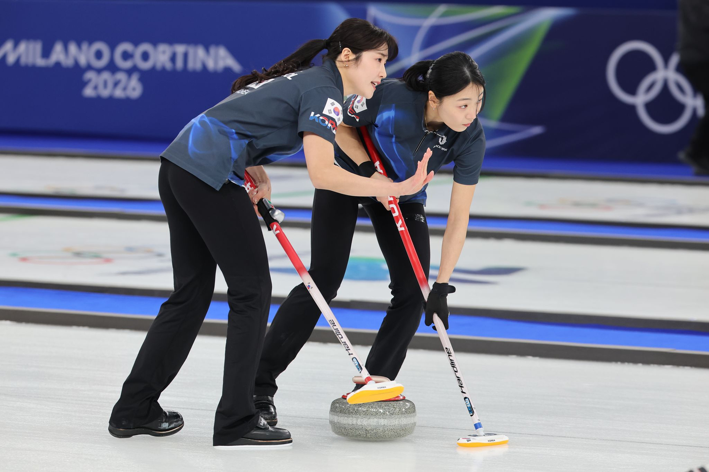  Seol Ye-eun and Kim Min-ji of South Korea sweep the ice during the women’s curling round-robin match against China at the 2026 Milan-Cortina Winter Olympics, held at the Cortina Curling Olympic Stadium in Cortina d’Ampezzo, Italy, on Feb. 16. [YONHAP] 
