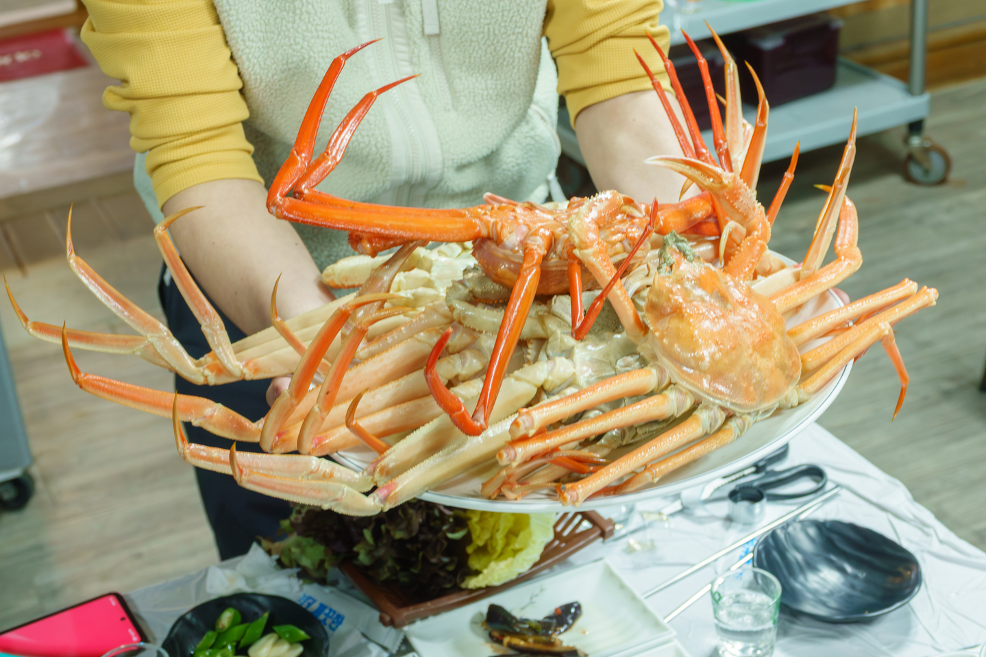 A restaurant owner holds freshly steamed snow crabs and red crabs at a local restaurant, Wangdolhoe Soosan. [GNC 21]