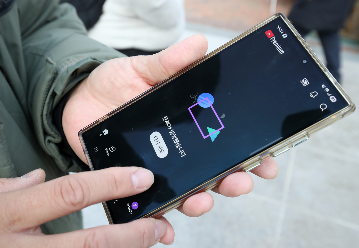 A person holds a phone showing YouTube's homepage. The video platform experienced a service error on Feb. 18. [NEWS1]