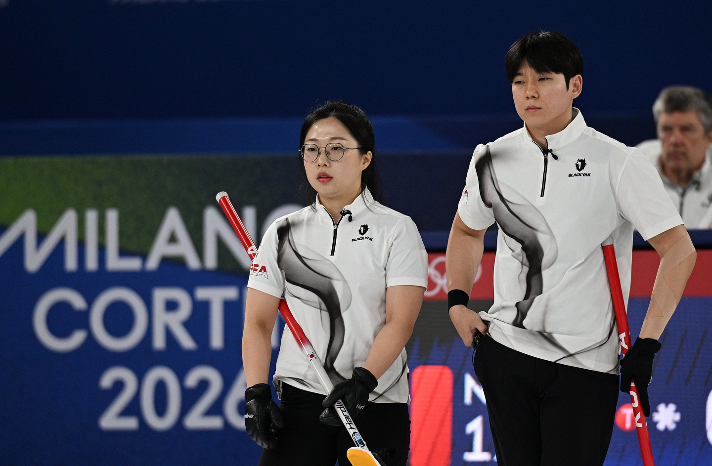 Jeong Yeong-seok, right, and Kim Seon-yeong of Korea look on during their match against Kristin Skaslien and Magnus Nedregotten of Norway during a curling mixed doubles round at the Cortina Curling Olympic Stadium in Cortina d'Ampezzo, Italy, on Feb. 9. [REUTERS/YONHAP]