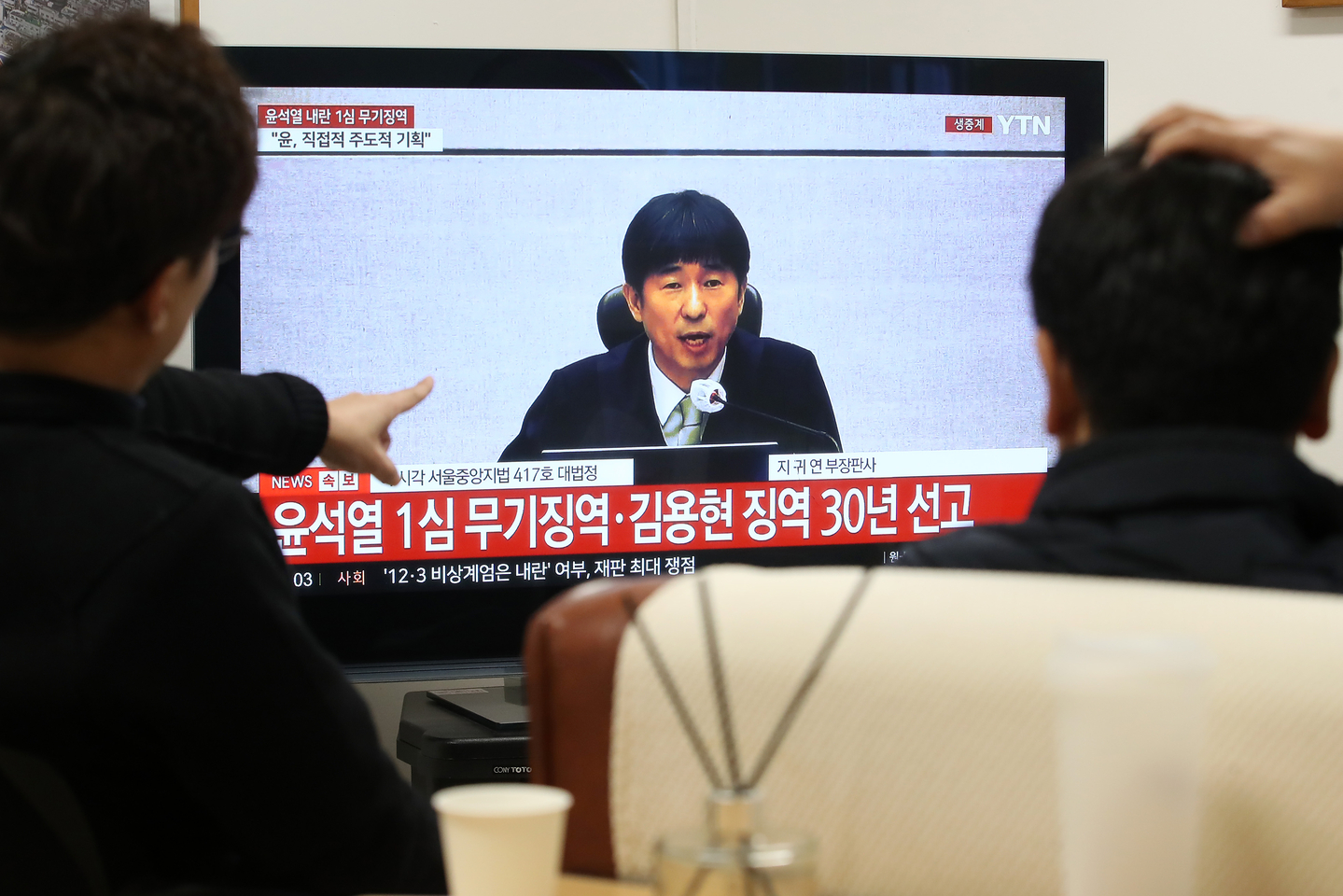 Office workers watch a live television broadcast of former President Yoon Suk Yeol’s first trial verdict on charges including leading an insurrection at an office in Dalseo District, Daegu, on Feb. 19. [NEWS1]
