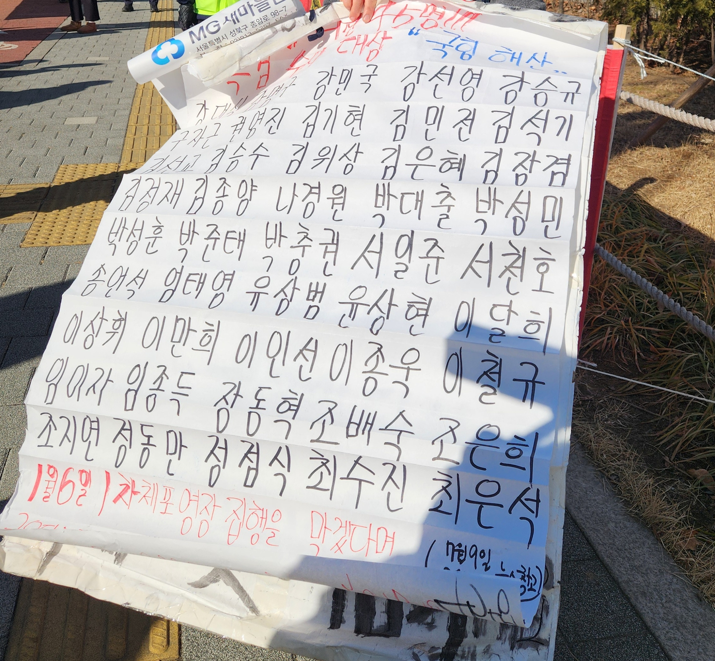 A sheet listing the names of 45 People Power Party lawmakers is seen at a rally by a civic group, the name of which translates to "Candlelight Action," calling for a death sentence for former President Yoon Suk Yeol — after Yoon was sentenced to life in prison on charges including leading an insurrection — in Seoul on Feb. 19. [LEE GYU-RIM]