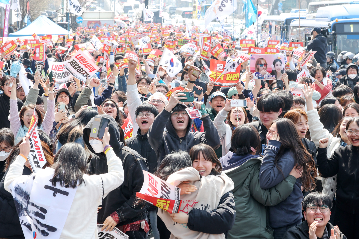 People outside President Yoon Suk Yeol's official residence in Yongsan District, central Seoul, celebrate upon hearing that the Constitutional Court dismissed him from office on April 4, 2025. [NEWS1]