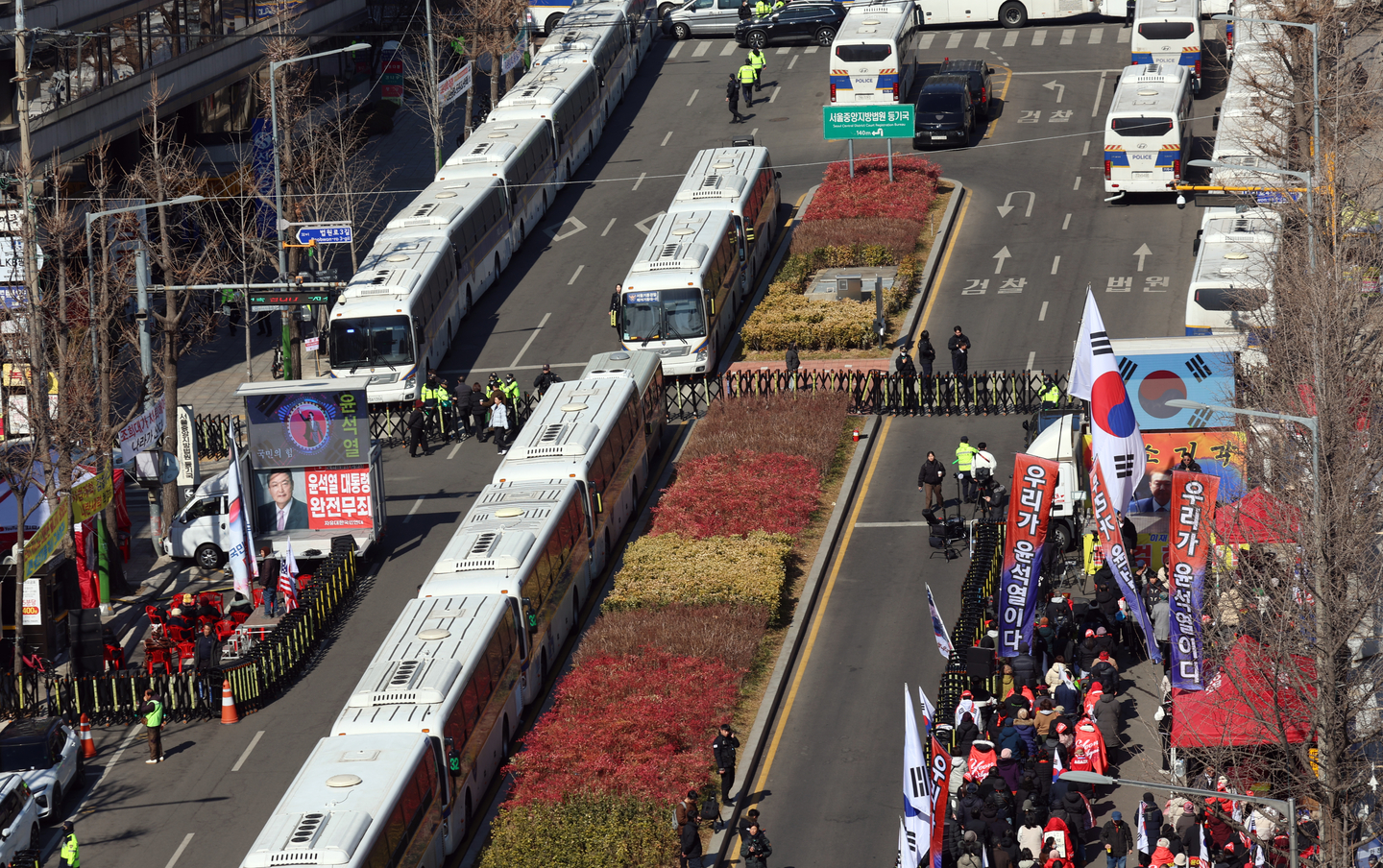 Police buses are parked near the Seoul Central District Court in Seocho District, southern Seoul, on Feb. 19, ahead of the court's sentencing hearing for former President Yoon Suk Yeol on charges of leading an insurrection. A pro-Yoon rally is also pictured in this photo. [NEWS1]