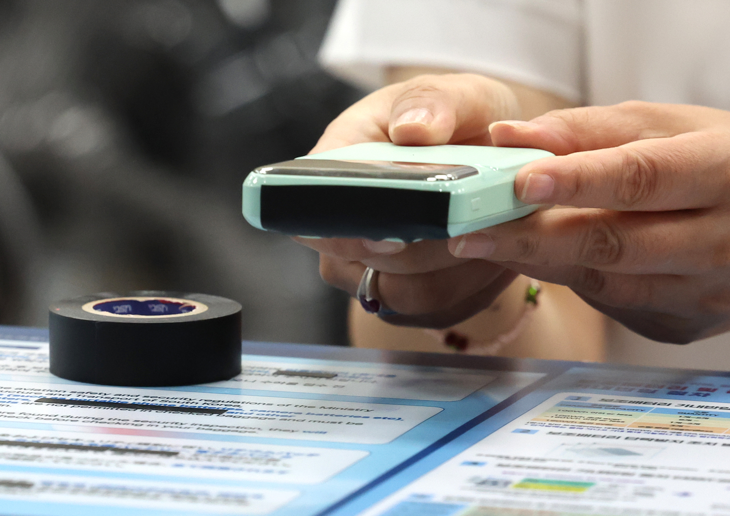 An airline employee is seen taping up a portable battery at a check-in counter inside Gimhae International Airport in Busan on Sept. 1, 2025. [NEWS1]