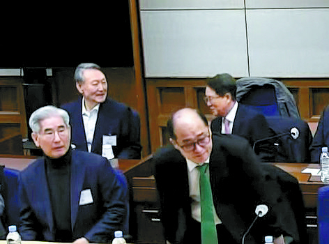 Former President Yoon Suk Yeol, behind left, talks to his attorney while awaiting a verdict on his insurrection charges at the Seoul Central District Court in southern Seoul on Feb. 19, 2026. The court sentenced Yoon to life in prison for leading an insurrection by declaring martial law on Dec. 3, 2024. [SEOUL CENTRAL DISTRICT COURT]