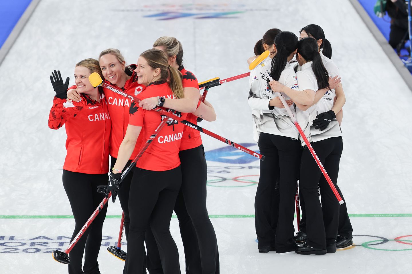 Members of Korea’s women’s curling team, right, react after a 10-7 loss to Canada in a round-robin match at the Milan?Cortina Winter Olympics at the Cortina Curling Olympic Stadium in Italy on Feb. 19, 2026. [YONHAP]