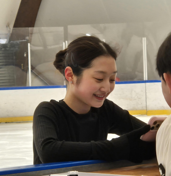 Shin Ji-a smiles while watching a video of her practice routine at an ice rink in Milan, Italy, on Feb. 10. [YONHAP] 