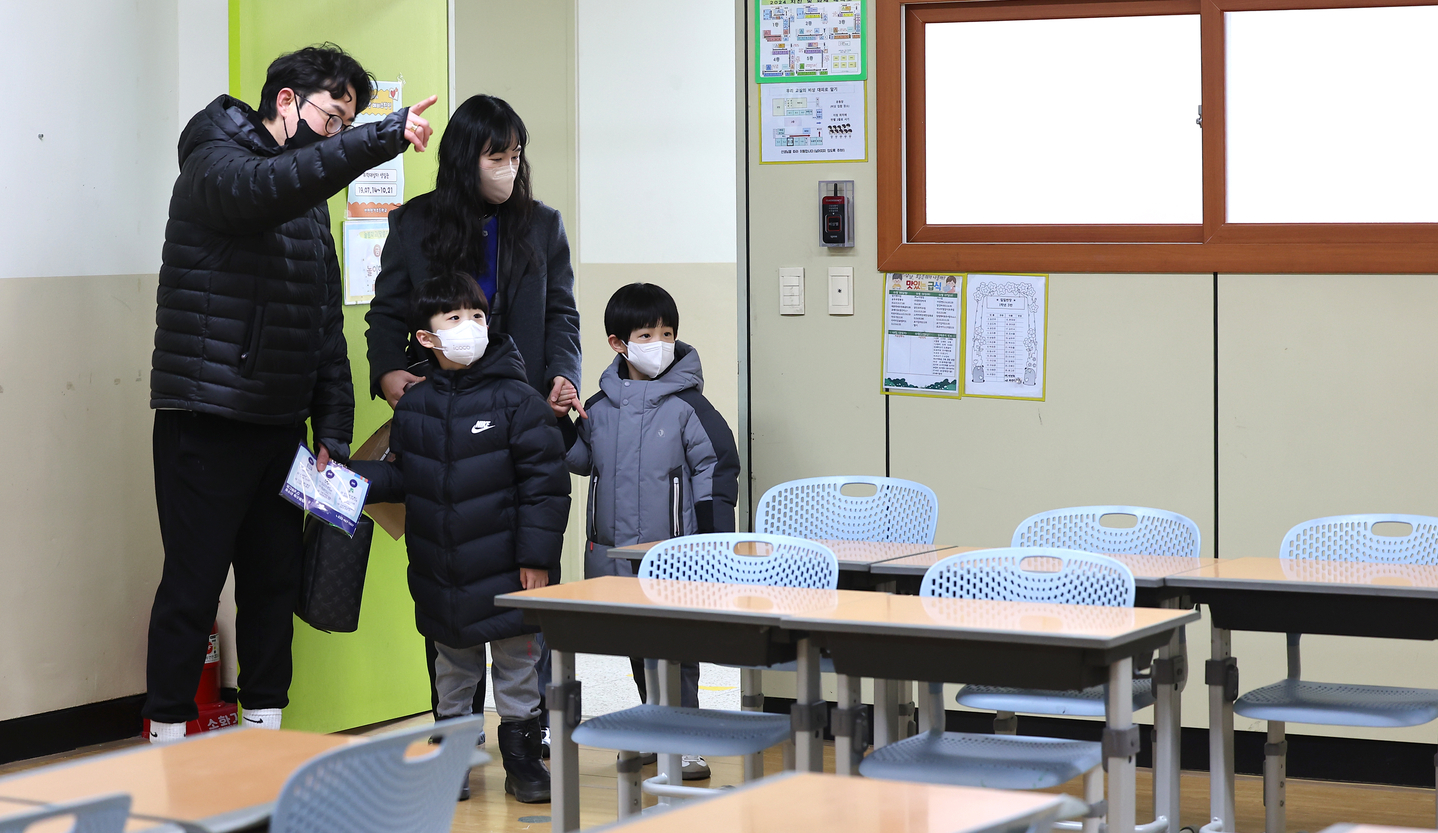 Prospective students and their parents look around a classroom during an orientation session for new students at Jeonggak Elementary School in Incheon on Jan. 6. [YONHAP]