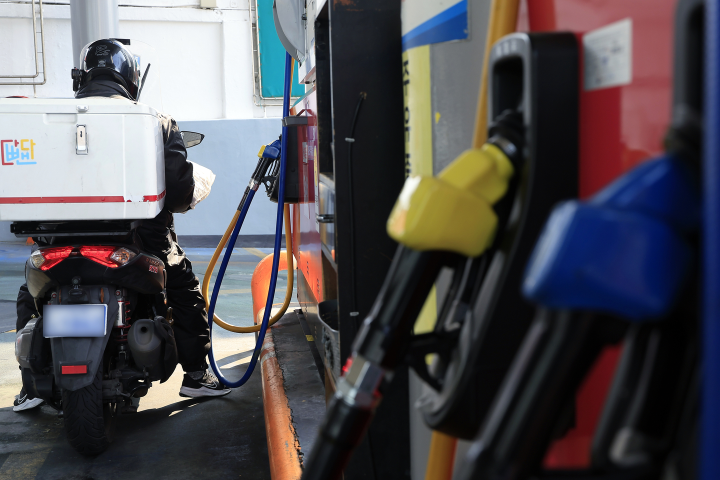 A bike rider is seen refilling their tank at a gas station in Seoul on Feb. 20. [NEWS1]