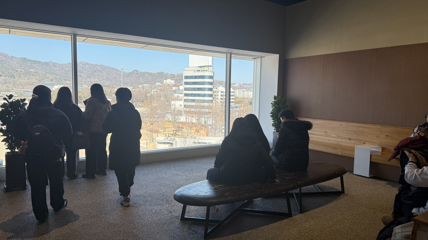 Visitors take in the view of Gwanghwamun Square as well as Gwanghwamun from a seating are within an exhibition located on the fifth floor of the National Museum of Korean Contemporary History in Jongno DIstrict, central Seoul. [WOO JI-WON]