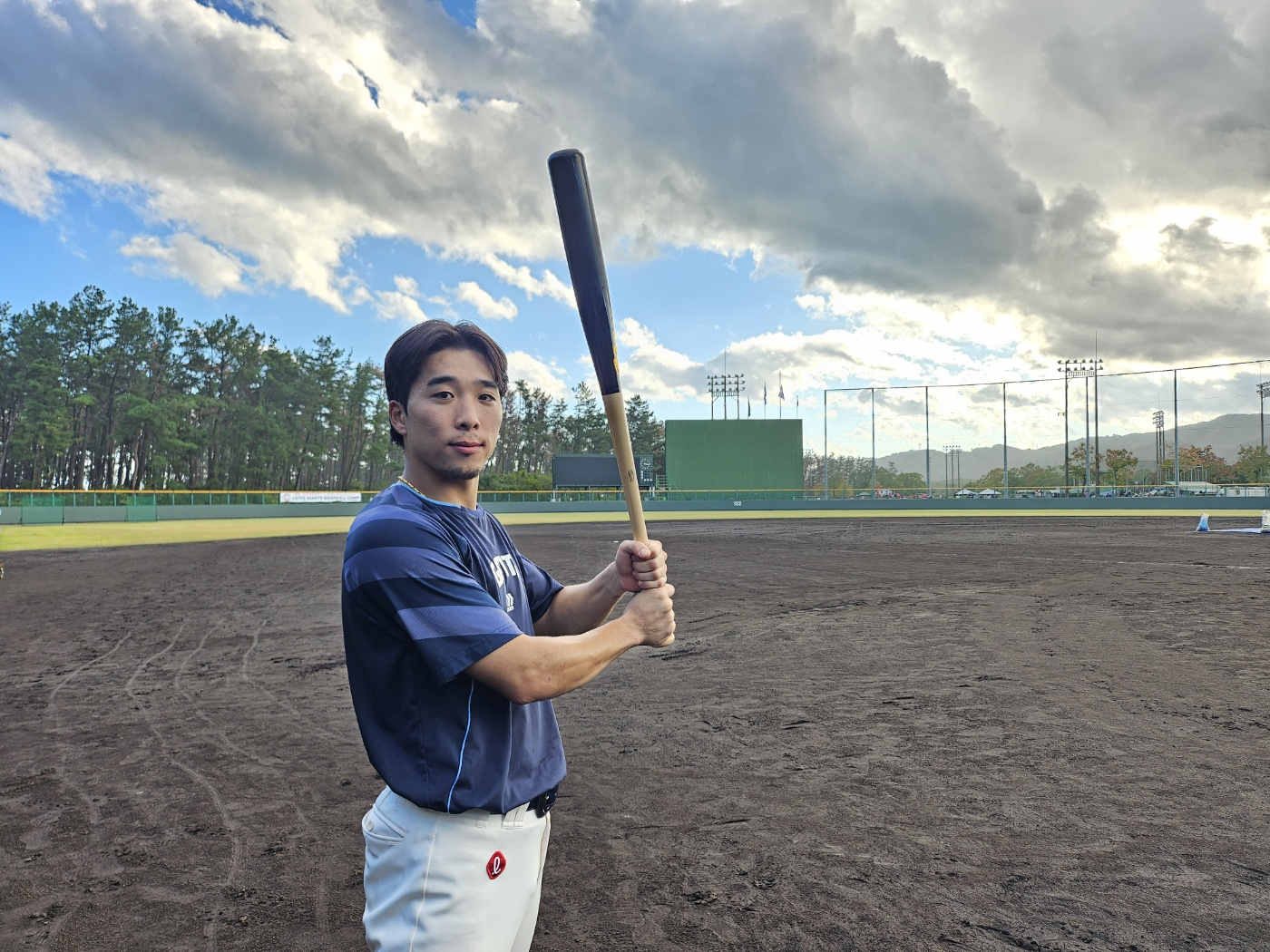 Korean baseball player Kim Dong-hyeok poses with his bat on the training field. [LOTTE GIANTS/YONHAP]