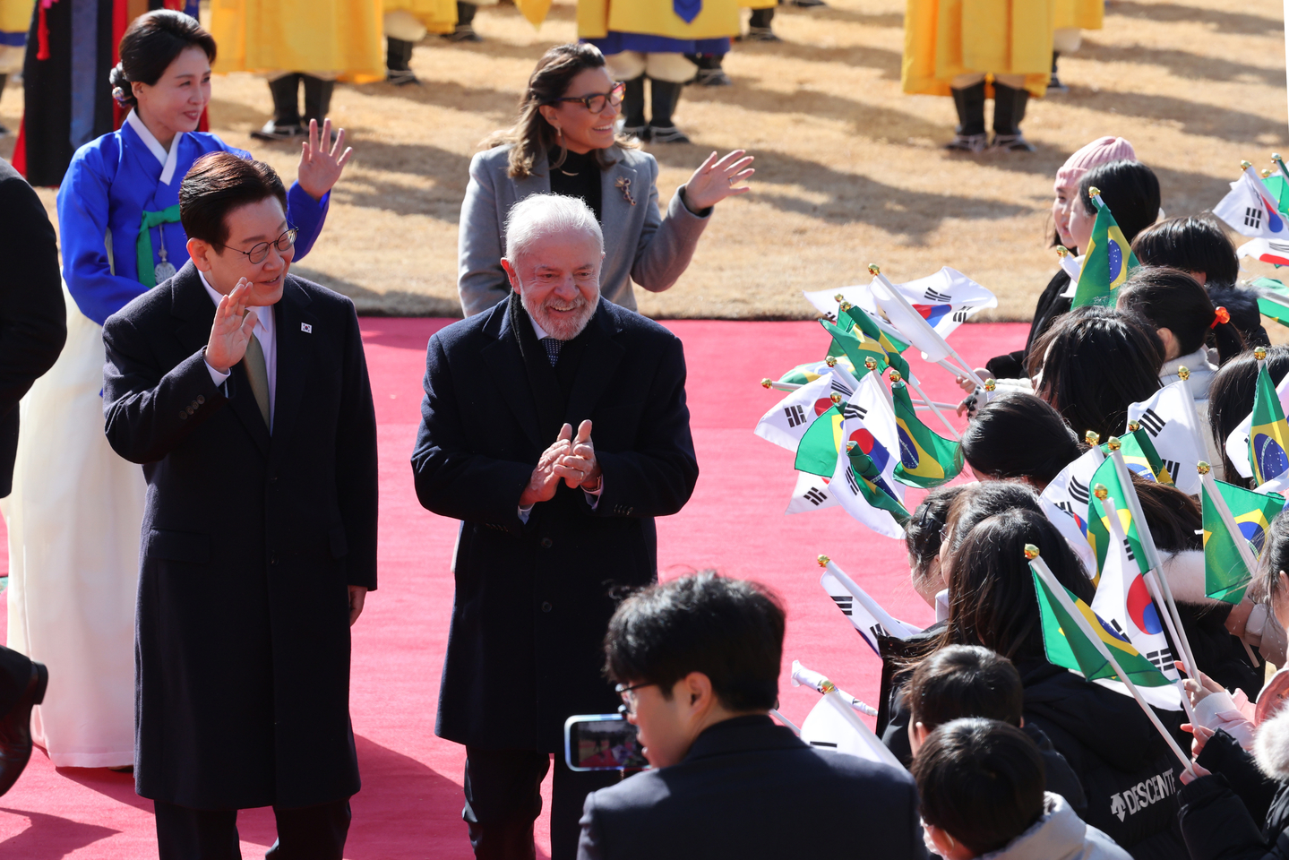 President Lee Jae Myung, left, and Brazilian President Luiz Inacio Lula da Silva wave during an official welcome ceremony at the Blue House in central Seoul on Feb. 23, ahead of their bilateral summit. [JOINT PRESS CORPS]