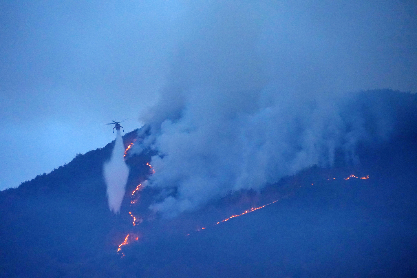 A Korea Forest Service wildfire suppression helicopter conducts firefighting operations at a wildfire site in Geomse-ri, Samnangjin-eup, Miryang, South Gyeongsang, on Feb. 24, the second day of the blaze. [KOREA FOREST SERVICE]