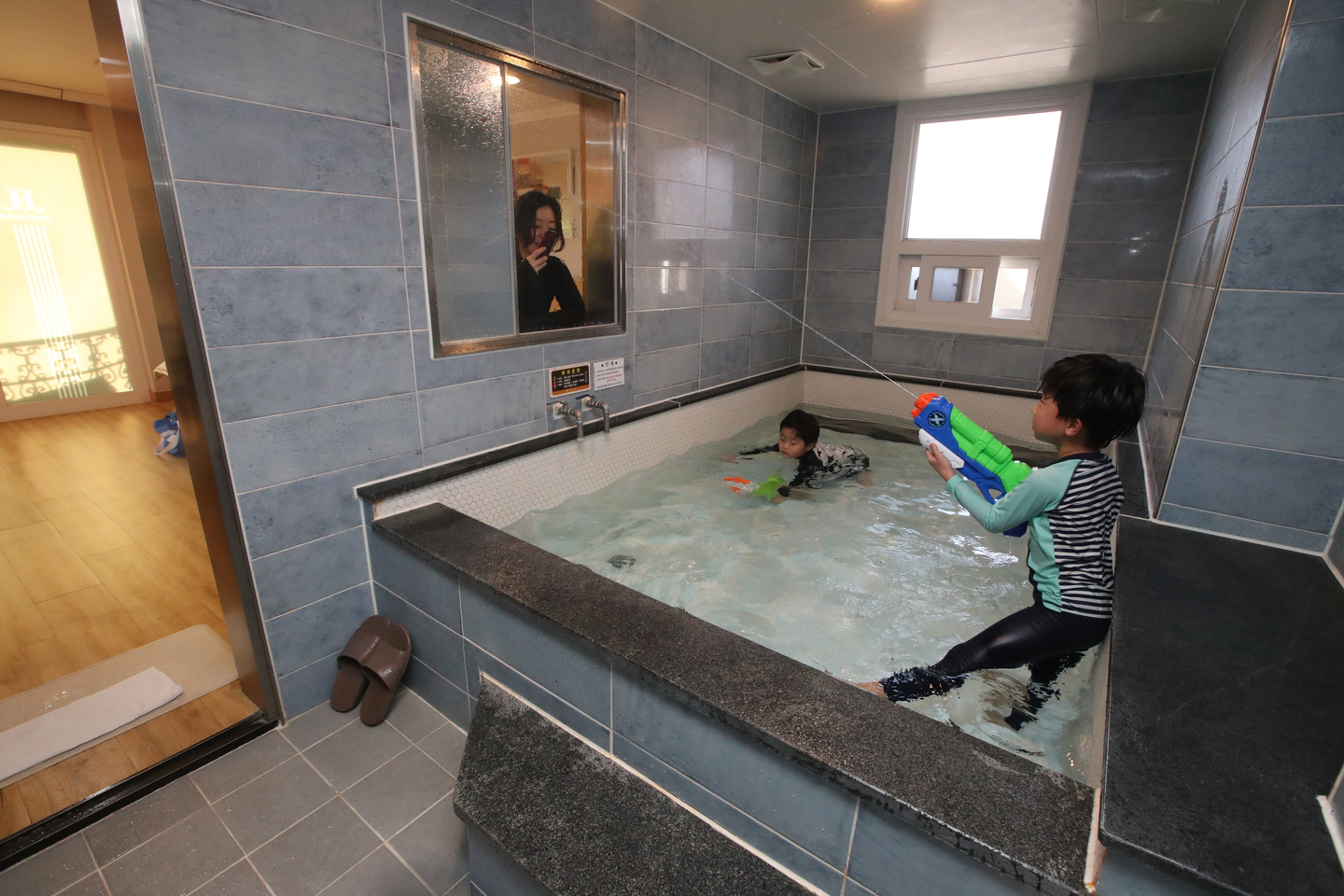 Children play in a private family bath at a hotel in Bugok-myeon, Changnyeong County, South Gyeongsang, on Nov. 25, 2020. [SONG BONG-GEUN] 