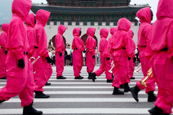 Performers dressed as “Squid Game” (2021-25) soldiers march in a parade through central Seoul, followed by a fan event with cast to celebrate the release of the third season of Netflix's hit series, in Seoul, on June 28, 2025. [REUTERS/YONHAP]