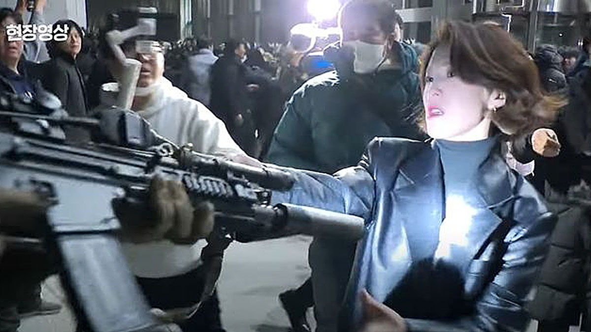 Ahn Gwi-ryeong, deputy spokesperson at the Blue House, is seen grabbing the barrel of a soldier’s rifle during emergency martial law at the National Assembly on Dec. 3, 2024. [JOONGANG ILBO]
