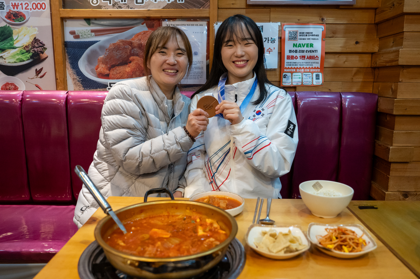 Snowboard medalist Yu Seung-eun poses for a photo holding a bronze medal with her mom at a kimchi stew restaurant in Sangam-dong, western Seoul on Feb. 21. [JOONGANG]