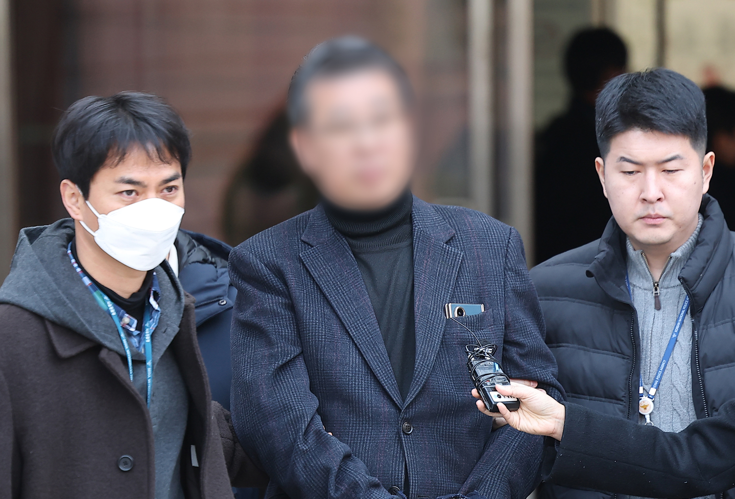 The head of a residential facility for people with developmental disabilities in Ganghwa, Incheon, center, attends a pretrial detention hearing at Seoul Central District Court in Seocho District, southern Seoul, on Feb. 19. [YONHAP]