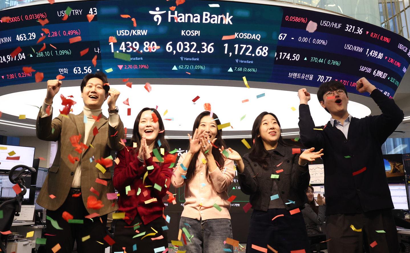 Employees celebrate in the dealing room of Hana Bank’s headquarters in Jung District, central Seoul, on Feb. 25 after the Kospi index surpassed the 6,000-point mark at the opening bell. [NEWS1]