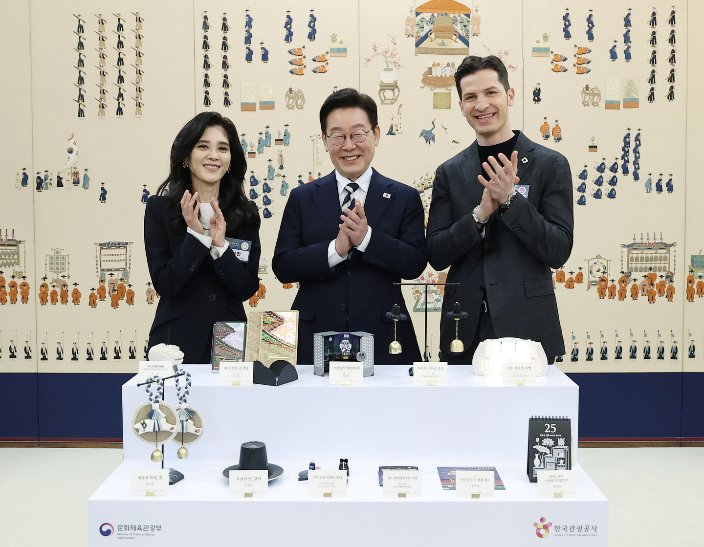 President Lee Jae Myung, center, poses for a commemorative photo with Lee Boo-jin, left, CEO of Hotel Shilla and chairperson of the Visit Korea Committee, and Alberto Mondi, vice president of the Italian Chamber of Commerce in Korea, in front of souvenir contest winning entries, at a national tourism strategy meeting at the Blue House in central Seoul on Feb. 25. [JOINT PRESS CORPS]