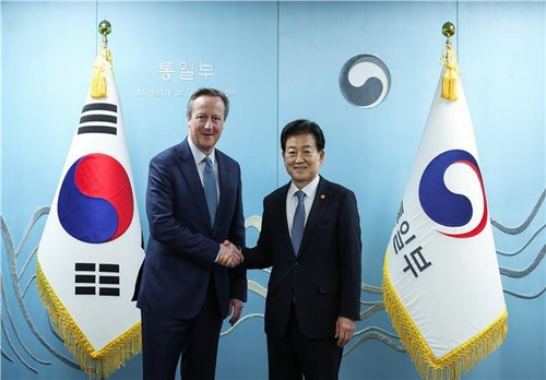 Unification Minister Chung Dong-young, right, shakes hands with David Cameron, former British prime minister, during their meeting in Seoul on Feb. 24. [MINISTRY OF UNIFICATION]