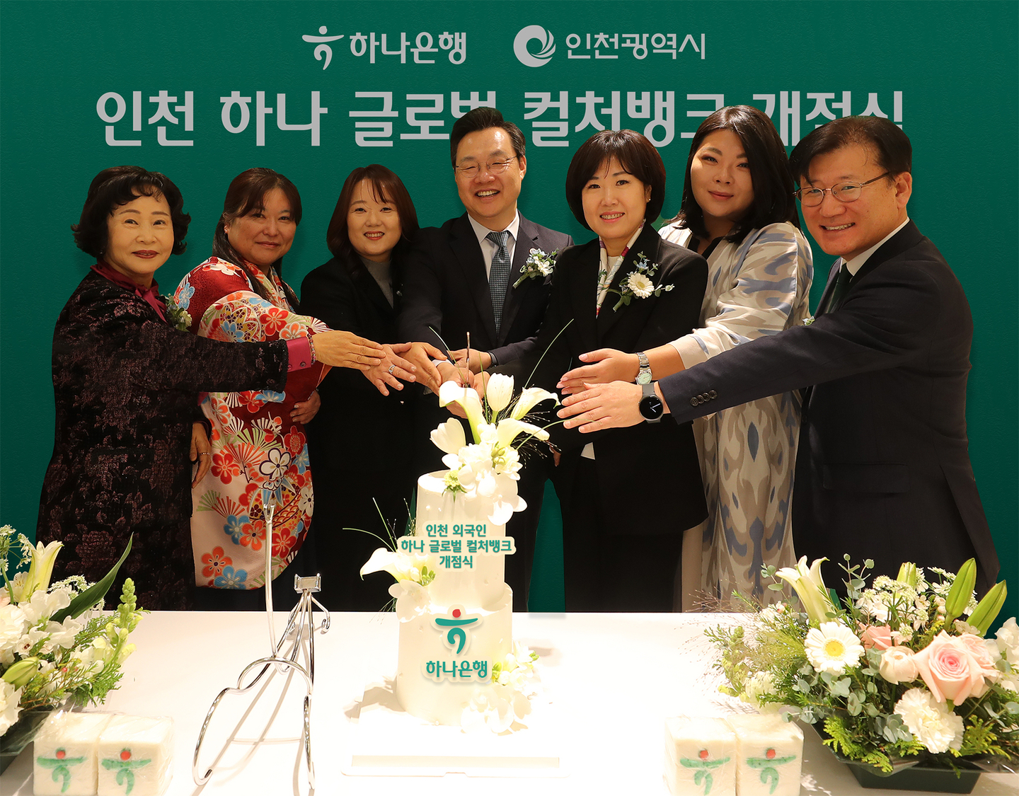 Officials, including Kim Mi-sook, deputy president of Hana Bank’s Joongang Business Group, third from right, and Ha Byeong-pil, deputy mayor of Incheon, fourth from right, pose for a commemorative photo while cutting a celebration cake at the opening of the Incheon Hana Global Culture Bank on the second floor of Hana Bank’s Namdong Industrial Complex Financial Center branch in Incheon in a photo shared on Feb. 25. [HANA BANK]