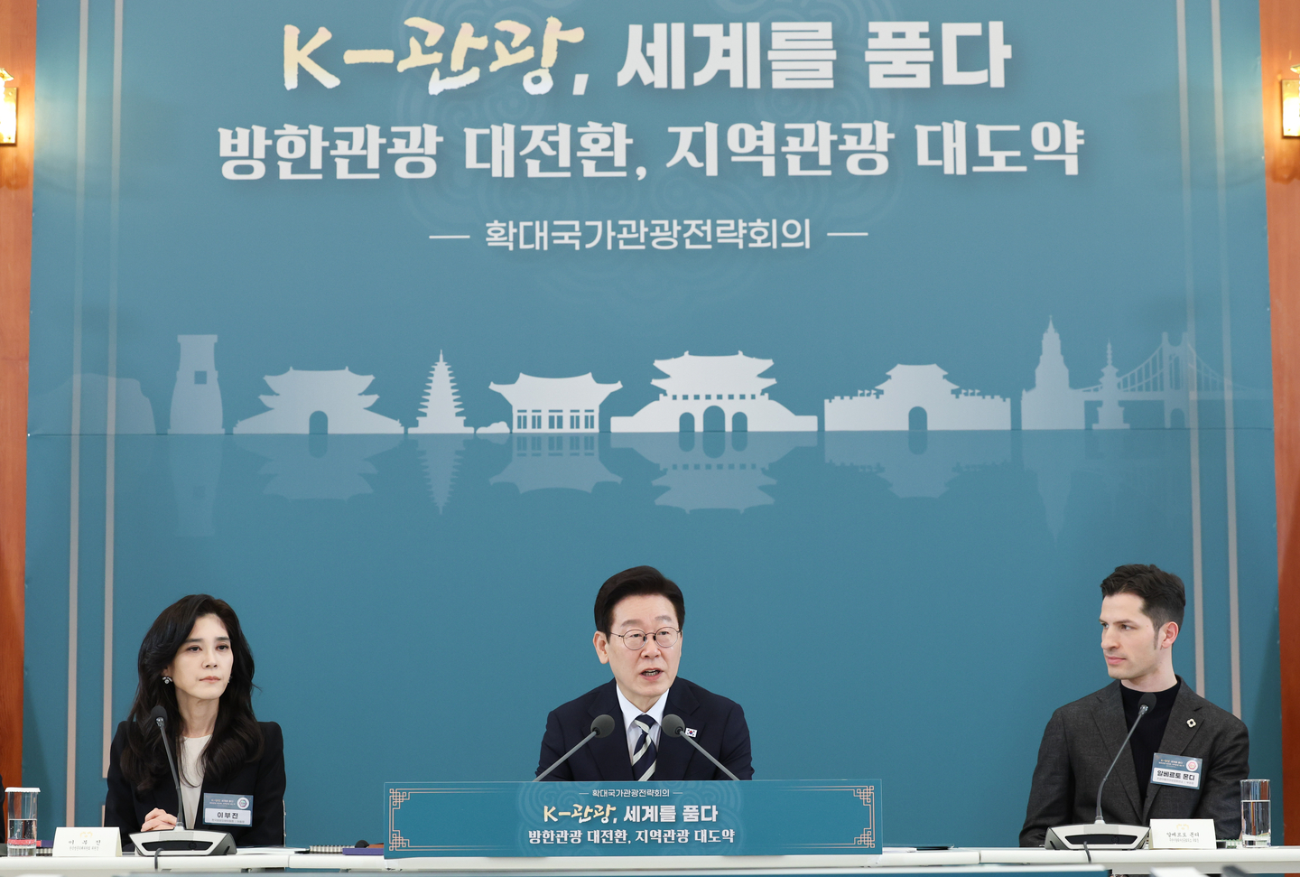 President Lee Jae Myung, center, speaks at a national tourism strategy meeting attended by government officials and public sector participants including Lee Boo-jin, left, CEO of Hotel Shilla and chairperson of the Visit Korea Committee, and Alberto Mondi, right, vice president of the Italian Chamber of Commerce in Korea at the Blue House in central Seoul on Feb. 25. [JOINT PRESS CORPS]