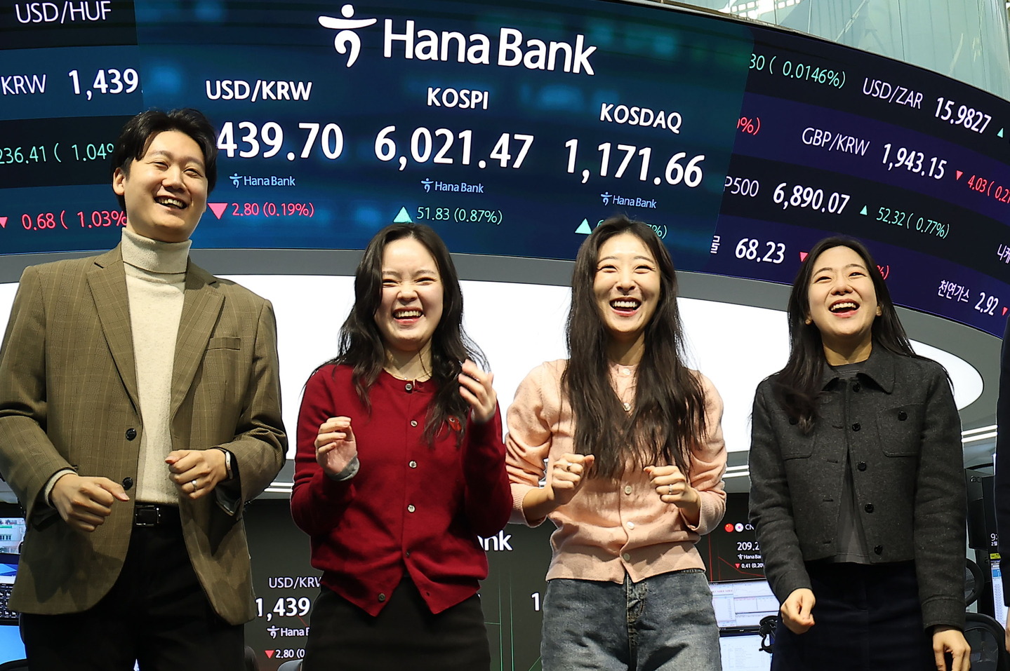 Hana Bank employees at a trading room in central Seoul celebrate as the Kospi surpasses 6,000 points during intraday trading on Feb. 25. [YONHAP] 