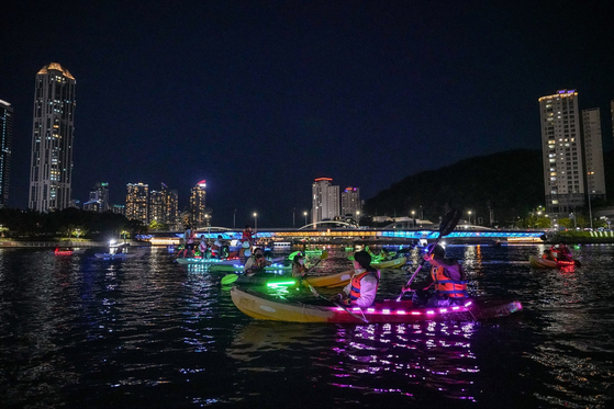 Kayakers are seen during the Starry Suyeonggang River: LED Kayak Experience festival in Busan in 2024. [BUSAN TOURISM ORGANIZATION]