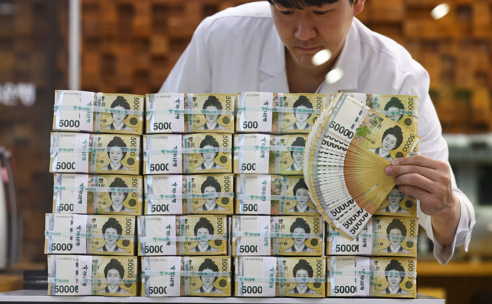 An employee displays 50,000 won bills at Hana Bank's Counterfeit Notes Response Center in Jung District, central Seoul, on Sept. 25, 2023. [YONHAP]